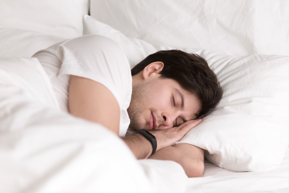 En ung man sover bär fitness armband