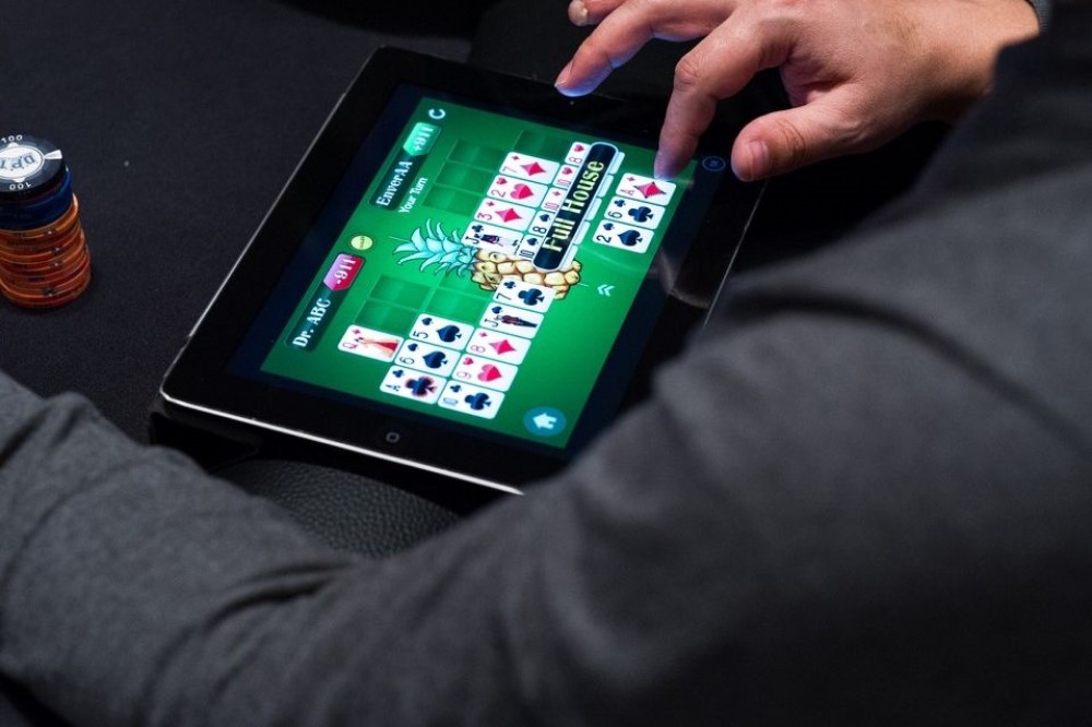 En man sitter i kasinot och spelar online casino på sin surfplatta